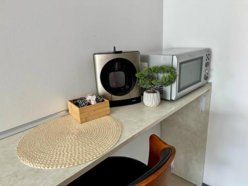 a microwave and a television on a table at MIRA Apartment SEA PARADISE in Kavarna