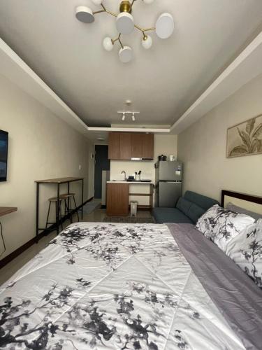 Un dormitorio con una cama grande y una cocina. en Cayden Staycation, en Lapu Lapu City