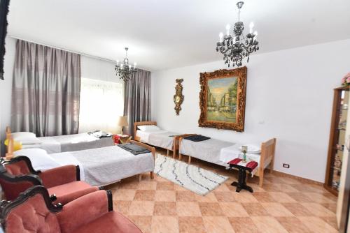 a room with four beds and a painting on the wall at Marku in Shkodër