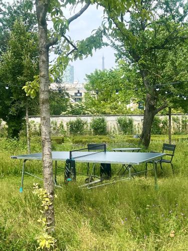 a picnic table in the grass next to a tree at Domaine de la Reine Margot Paris-Issy - MGallery Collection in Issy-les-Moulineaux
