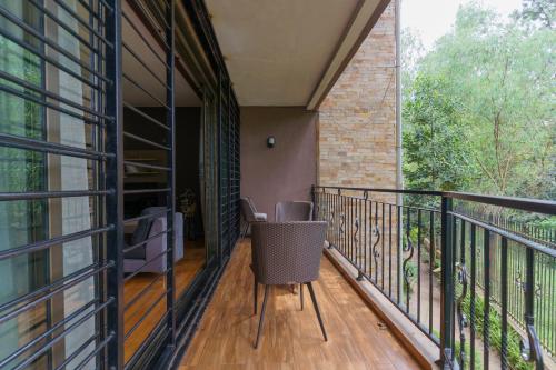 a balcony with a table and chairs on it at Acacia Green Service Apartments in Kampala
