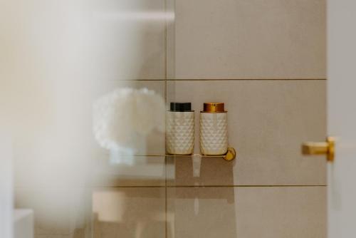 two bottles sitting on a glass shelf in a bathroom at Skyone Lux 2Bed room Aprt in BoxHill with car park in Box Hill