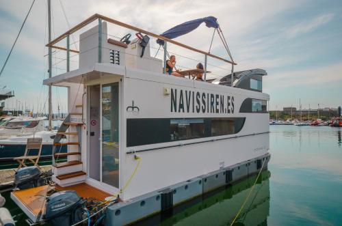 ein weißes Boot ist im Wasser angedockt in der Unterkunft Exclusivas vistas al mar en casa barco, pleno centro, terraza, parking in A Coruña
