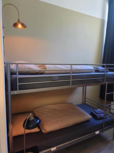 two bunk beds in a room with a lamp at Stora Ekeberg vandrarhem in Axvall