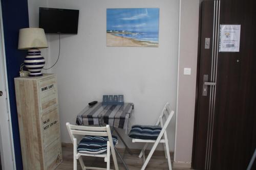 une chambre avec une table, deux chaises et une télévision dans l'établissement Studio Mer à Mastaing, à Mastaing