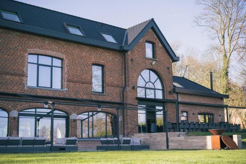 a brick building with benches in front of it at Gîte - Le Mont in Tournai