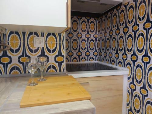 a kitchen with two wine glasses on a wall at Casa de Férias Palmeira in Faro