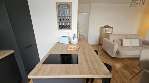 a living room with a table and a couch at Elegant apartment in a luxury residence in Arras