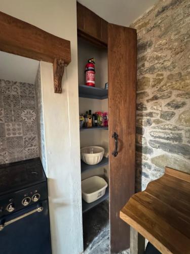 a kitchen with a stove and a shelf with food at Seven Sisters in Glastonbury