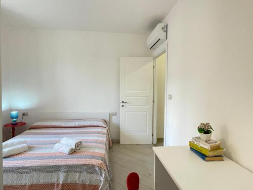 a small bedroom with two beds and a table at Appartamento fronte mare nel cuore di Stintino in Stintino
