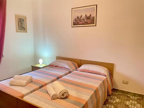 a bedroom with two beds with towels on them at Appartamento fronte mare nel cuore di Stintino in Stintino