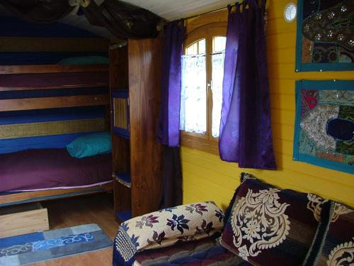 une chambre avec un lit superposé et une fenêtre dans l'établissement Roulotte de charme, à Doucier
