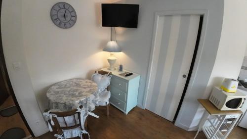 une pièce avec une commode bleue et une horloge au mur dans l'établissement Studio romantique à la campagne à Mastaing, à Mastaing