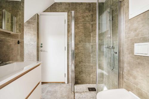 a bathroom with a glass shower with a toilet at DINBNB Apartments l 100m to Bryggen l Pet Friendly l Sleeps 4 l Smart-TV in Bergen