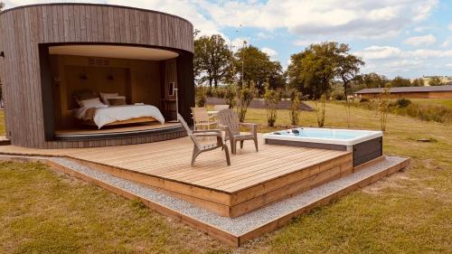 a bed and a table and chairs on a wooden deck at Domaine de Chabrague in Amou