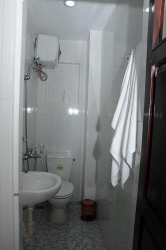 a white bathroom with a toilet and a sink at Thanh An 3 Guesthouse in Hue