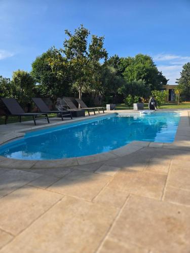 - une piscine d'eau bleue dans une terrasse dans l'établissement studio de charme, à Montbazin