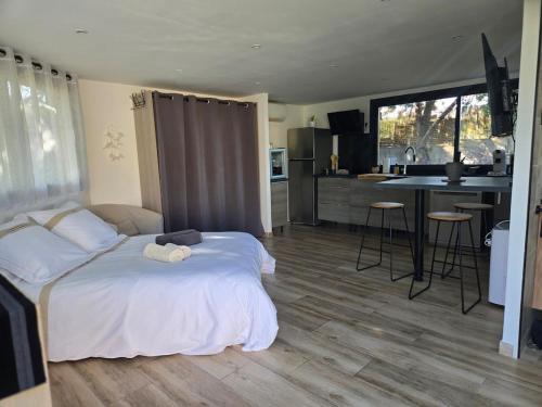 Cet appartement comprend une chambre avec un lit blanc et une cuisine. dans l'établissement studio de charme, à Montbazin