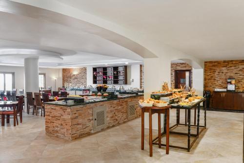 a large kitchen with a counter with tables and chairs at Aura Resort Sidi Abd El Rahman El Alamein in Sīdī ‘Abd ar Raḩmān