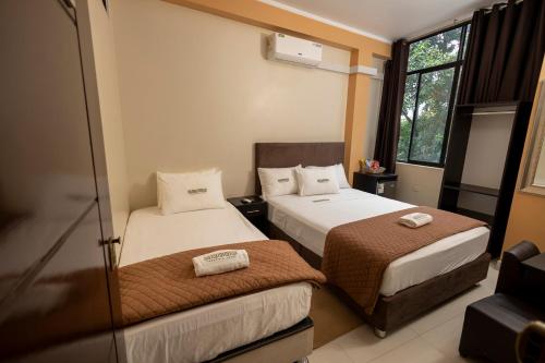 a hotel room with two beds and a window at Sonqu Tarapoto in Tarapoto