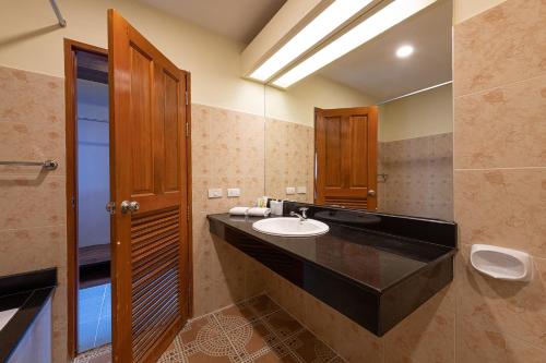 a bathroom with a sink and a mirror at Blue Beach Grand Resort And Spa in Rawai Beach