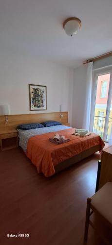a bedroom with a large bed with an orange blanket at The green house in Malcesine