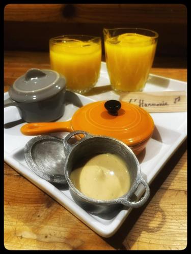 a tray with a bowl of soup and two glasses of orange juice at gite comme un accord in Saint Mathieu Du Parc