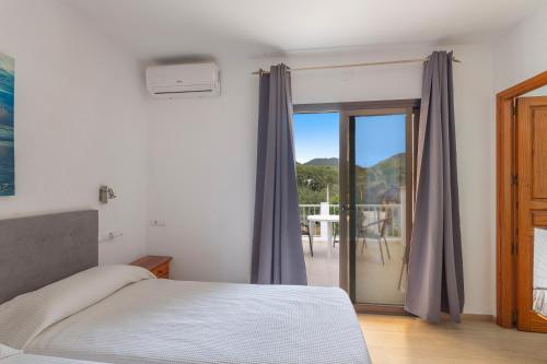 a bedroom with a bed and a sliding glass door at Pensión las 3 Golondrinas in Santa Eularia des Riu