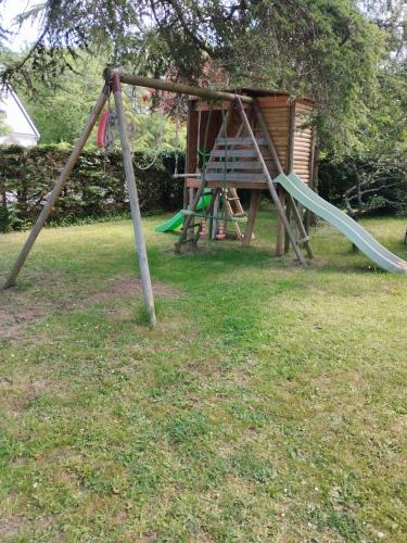 une aire de jeux avec un toboggan dans une cour dans l'établissement La Pérenne, à Pénestin