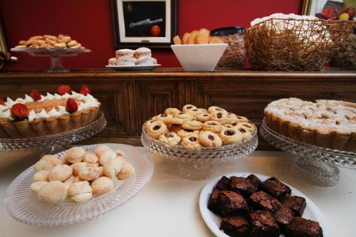 a table topped with different types of cakes and pastries at La Campiña Club Hotel & Spa in Santa Rosa