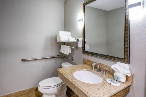 a bathroom with a sink and a toilet and a mirror at Baymont by Wyndham La Vergne Nashville I-24 East in La Vergne