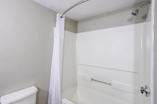 a bathroom with a shower curtain and a toilet at Baymont by Wyndham La Vergne Nashville I-24 East in La Vergne