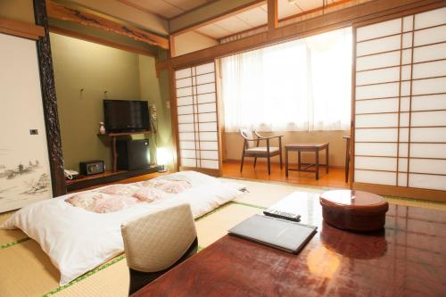 1 dormitorio con cama, mesa y sidra de mesa en Masunoi, en Mie