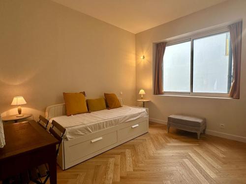 une chambre avec un lit avec des oreillers jaunes et une fenêtre dans l'établissement T3 - standing - spacieux - centre ville, à Vannes