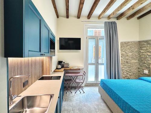 a bedroom with a bed and a kitchen with a sink at Casa La Margherita in Desenzano del Garda
