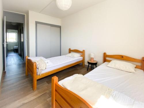 - une chambre avec 2 lits et un couloir dans l'établissement Appartement Résidence piscine, à Biscarrosse