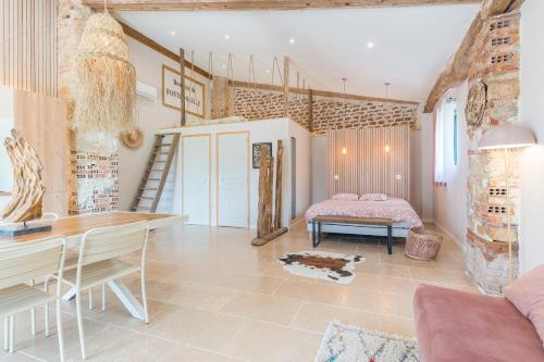 a room with a bed and a desk and a table at Le Loft in Esparron