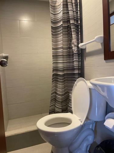 a bathroom with a blue toilet and a shower at HOSTAL Aly 3 in Otavalo