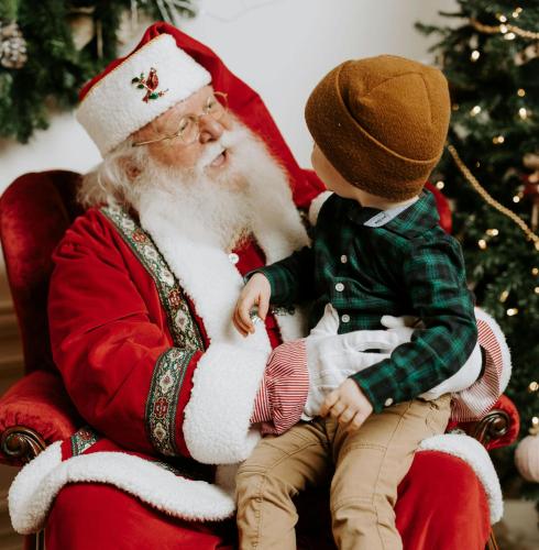 a child sitting on the lap of santa claus at SKOG - Aurora Igloos Resort in Kalix