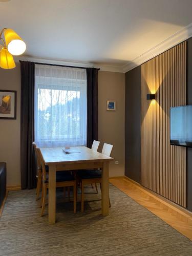 a dining room with a table and chairs and a window at S-VILLA Apartments im Schwarzwald in Schiltach