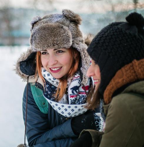 a woman is talking to another woman in the snow at SKOG - Aurora Igloos Resort in Kalix