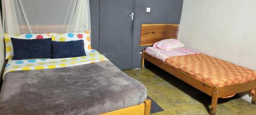 a room with two beds and a ottoman at Lusaka Backpackers in Lusaka