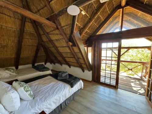 two beds in a room with a large window at Thula-Thula Private Game Lodge Mabalingwe in Bela-Bela