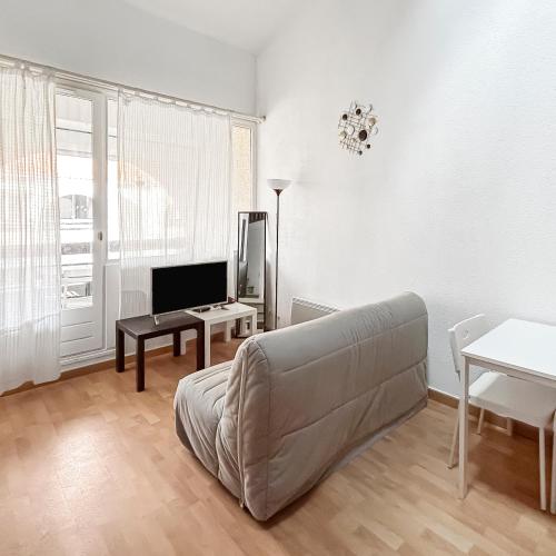 a living room with a couch and a table at Pied-à-terre idéal entre mer et port in Mauguio