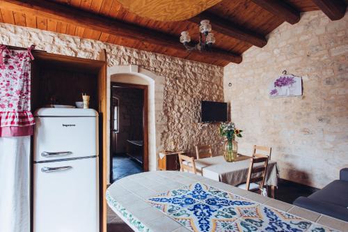 a kitchen with a refrigerator and a dining room with a table at Le Cacinare in Modica