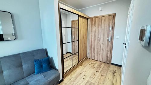 a living room with a couch and a sliding glass door at Apartament Pogodny 2 Z PARKINGIEM PODZIEMNYM in Chojnice