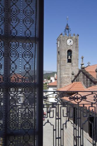 a view of a clock tower from a window at Mercearia da Vila in Ponte de Lima