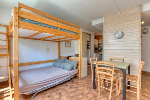 - une chambre avec des lits superposés, une table et une salle à manger dans l'établissement La Grande Motte Studio, à La Grande Motte