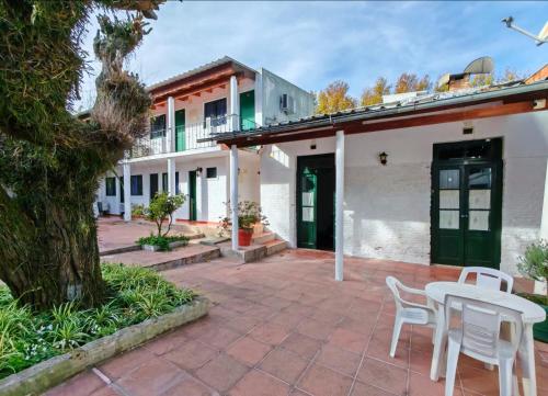 a patio with a table and chairs in front of a building at Hostel Colibri Colonia in Colonia del Sacramento