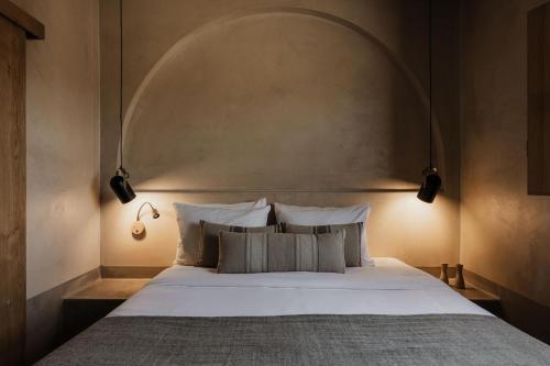 a bedroom with a large bed with an arch above it at Momi Slow Living Hotel in Hersonissos